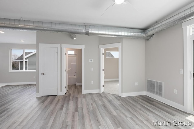 below grade area with light wood-style floors, baseboards, and visible vents