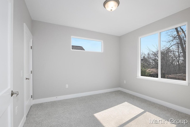 unfurnished room with carpet flooring and baseboards