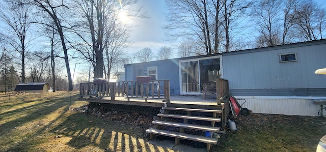 back of house with a storage shed, an outdoor structure, a yard, and a wooden deck