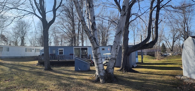 manufactured / mobile home featuring a front yard and a wooden deck