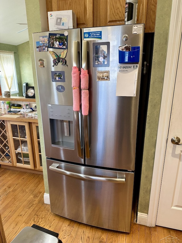 kitchen featuring brown cabinetry, light wood-style floors, and stainless steel fridge