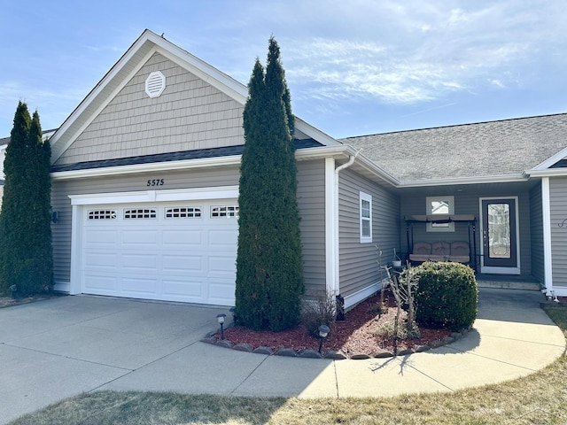 view of front of property featuring a garage, covered porch, concrete driveway, and a shingled roof