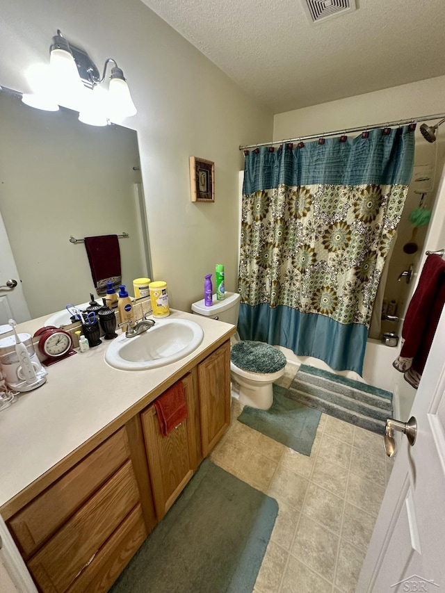 bathroom featuring vanity, tile patterned flooring, a textured ceiling, toilet, and shower / tub combo with curtain