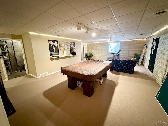 playroom featuring visible vents, a paneled ceiling, brick wall, and carpet flooring