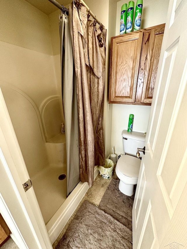 full bathroom featuring toilet and a stall shower