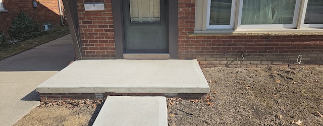 view of exterior entry with brick siding