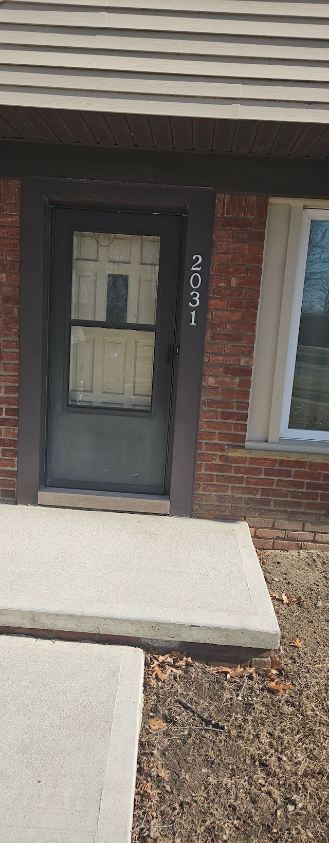 doorway to property with brick siding