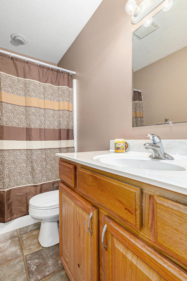 bathroom with a textured ceiling, toilet, vanity, and shower / bathtub combination with curtain