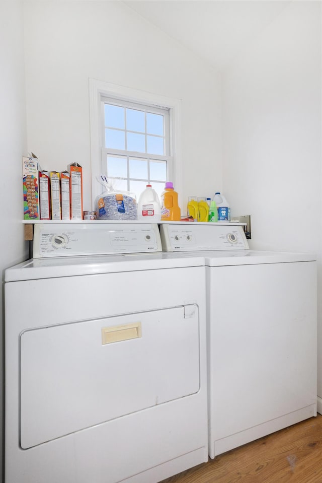 clothes washing area with separate washer and dryer, laundry area, and light wood finished floors