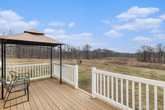 wooden deck featuring a gazebo, a yard, and a rural view