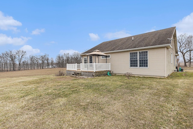 back of property featuring a gazebo, a lawn, a wooden deck, and roof with shingles