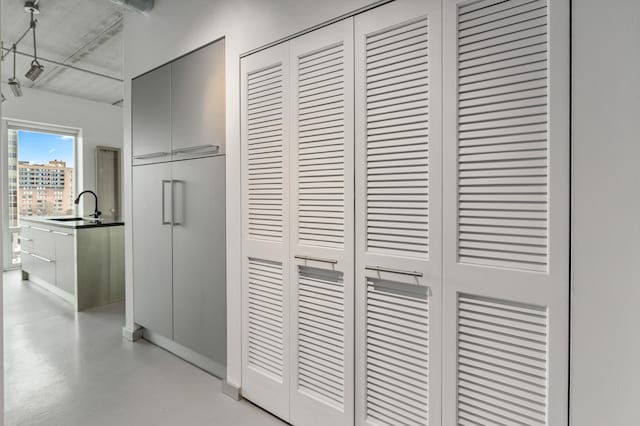 hall featuring concrete flooring and a sink