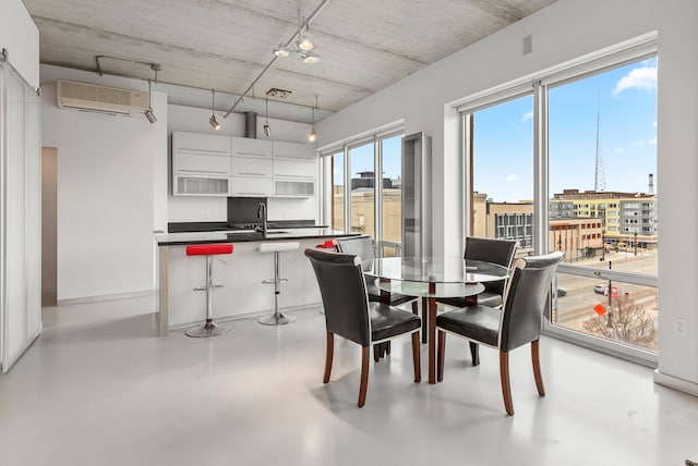 dining room featuring a wall mounted air conditioner, a view of city, and concrete flooring