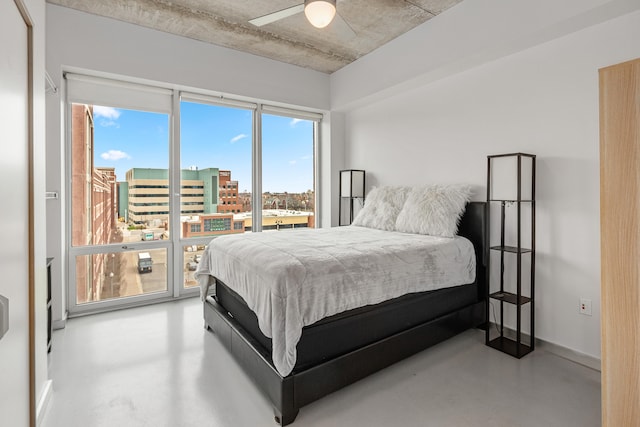 bedroom featuring a city view, finished concrete flooring, and a ceiling fan