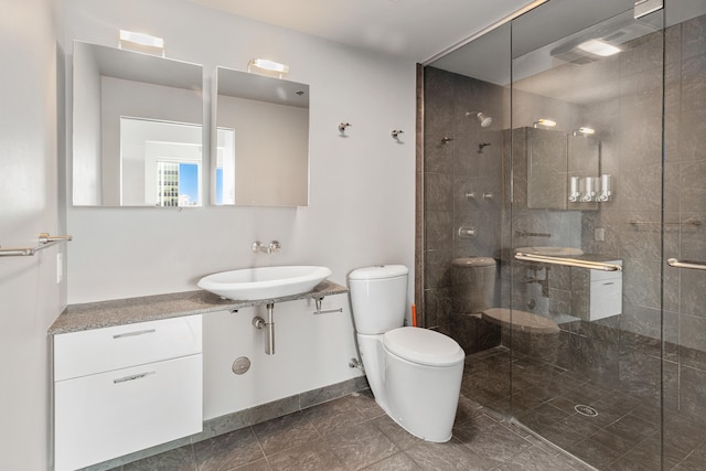 full bath featuring a stall shower, toilet, baseboards, and a sink