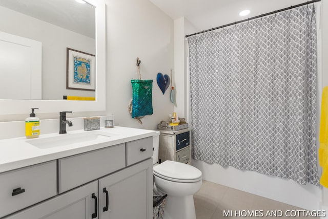 bathroom with tile patterned flooring, shower / bath combo with shower curtain, toilet, and vanity