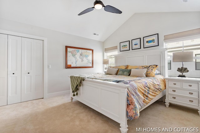 bedroom with visible vents, ceiling fan, light carpet, a closet, and high vaulted ceiling