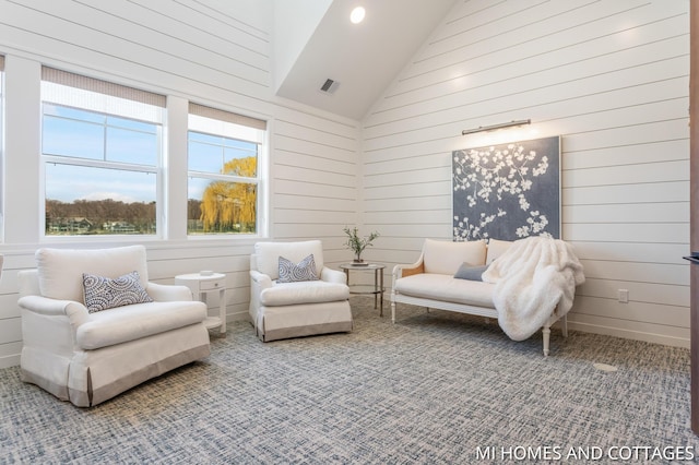 living area featuring visible vents, high vaulted ceiling, and carpet floors