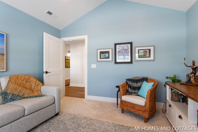 living area with vaulted ceiling, carpet flooring, visible vents, and baseboards