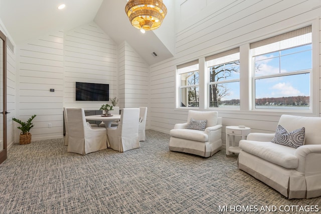 living area with visible vents, high vaulted ceiling, recessed lighting, wooden walls, and carpet flooring