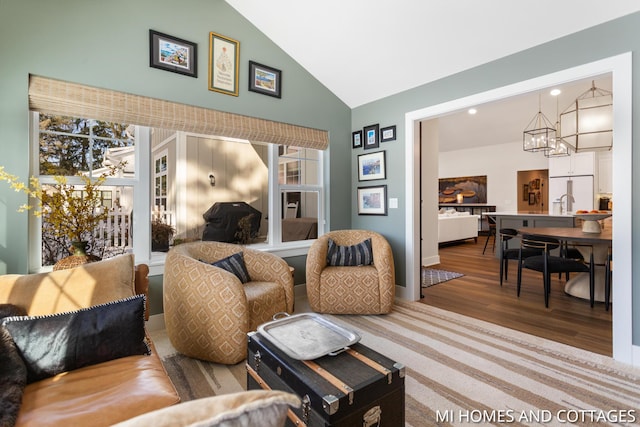 living area with high vaulted ceiling and wood finished floors