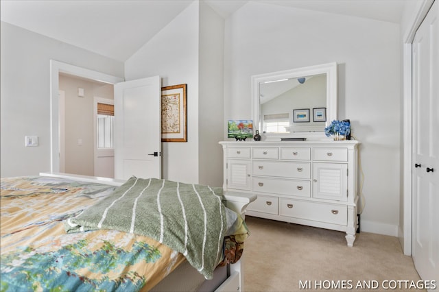 bedroom with light colored carpet, baseboards, and lofted ceiling