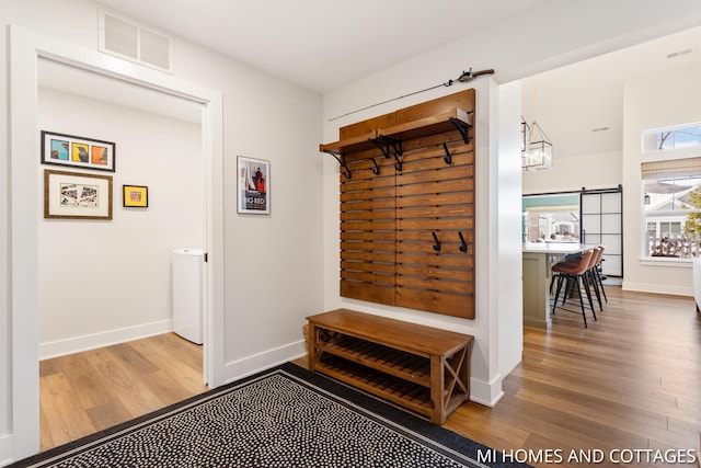 mudroom featuring visible vents, baseboards, and wood finished floors