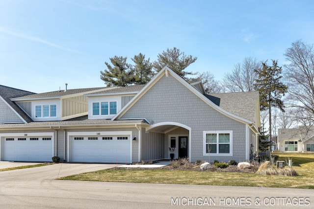 view of front of home with concrete driveway, a garage, and roof with shingles