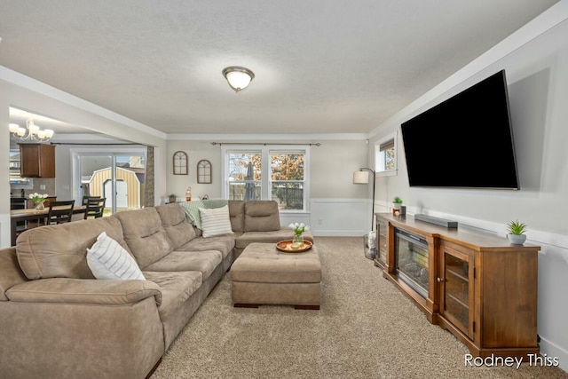 living area with wainscoting, ornamental molding, an inviting chandelier, and carpet floors