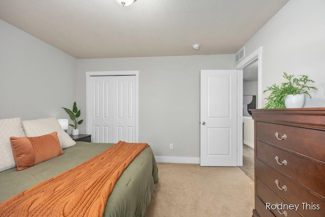 bedroom featuring a closet, baseboards, light colored carpet, and visible vents