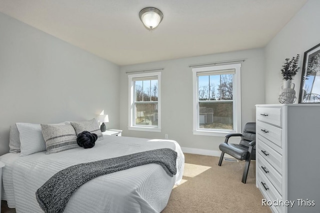 bedroom with light colored carpet and baseboards