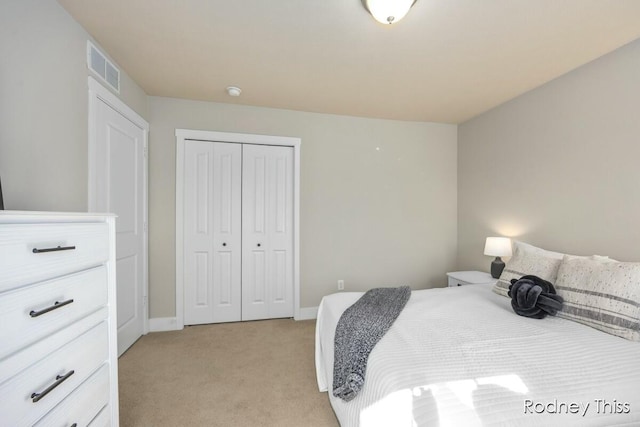 bedroom with a closet, visible vents, light colored carpet, and baseboards