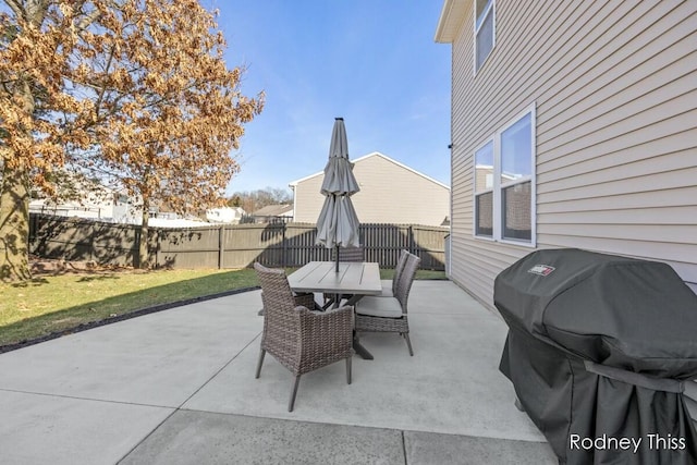 view of patio with outdoor dining area, a fenced backyard, and a grill