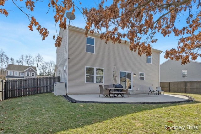 rear view of house featuring a patio area, a yard, and a fenced backyard