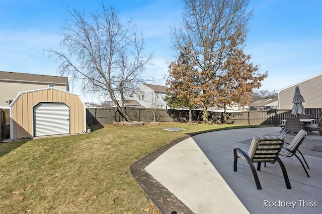 view of yard with a fenced backyard, a storage unit, an outbuilding, and a patio