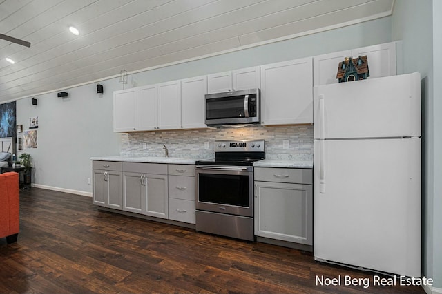 kitchen with light countertops, dark wood-type flooring, backsplash, and stainless steel appliances