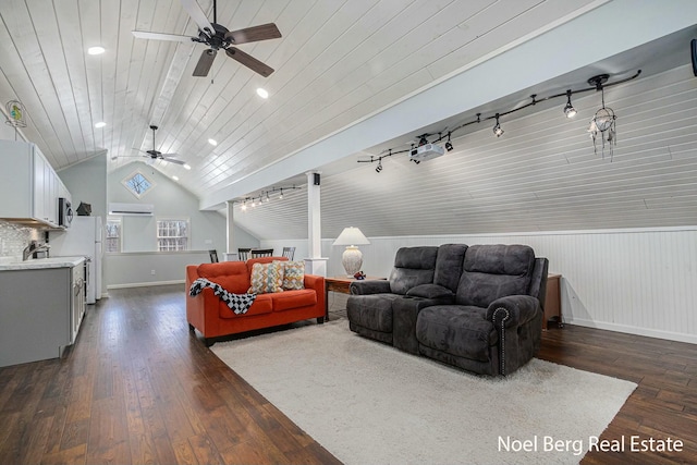 living room featuring dark wood-type flooring, lofted ceiling, rail lighting, baseboards, and wood ceiling