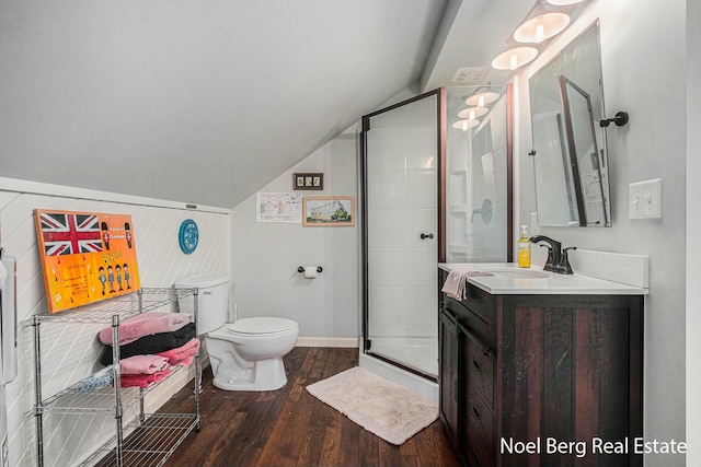 full bathroom with a stall shower, wood finished floors, vanity, and vaulted ceiling