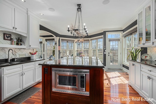 kitchen featuring a sink, dark wood-type flooring, dark countertops, and appliances with stainless steel finishes