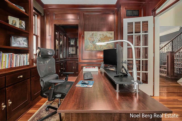 office with a decorative wall, ornamental molding, and wood finished floors