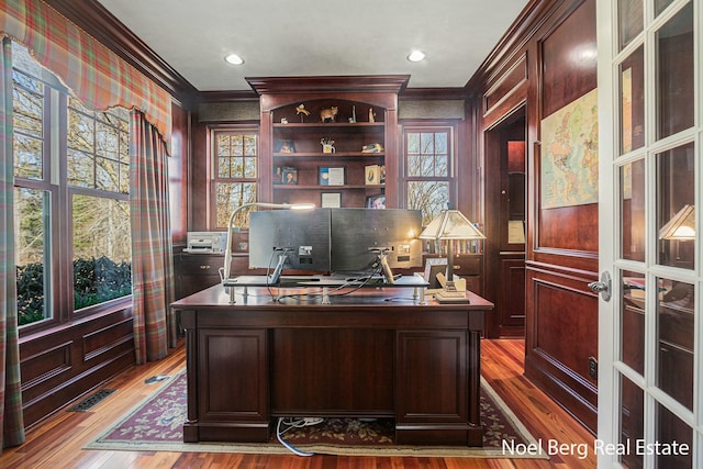 office space featuring plenty of natural light, wood finished floors, and ornamental molding