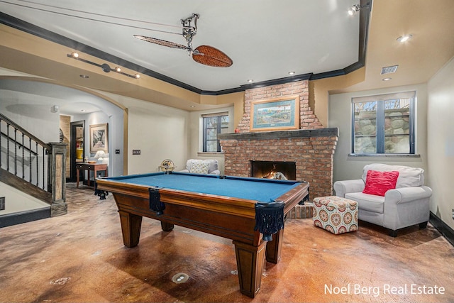 game room featuring visible vents, baseboards, finished concrete floors, crown molding, and a brick fireplace