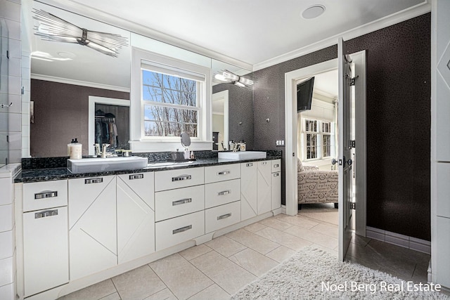 bathroom featuring double vanity, ornamental molding, and a sink