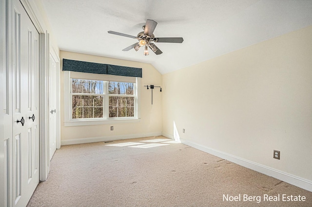 unfurnished bedroom featuring vaulted ceiling, a closet, baseboards, and carpet floors