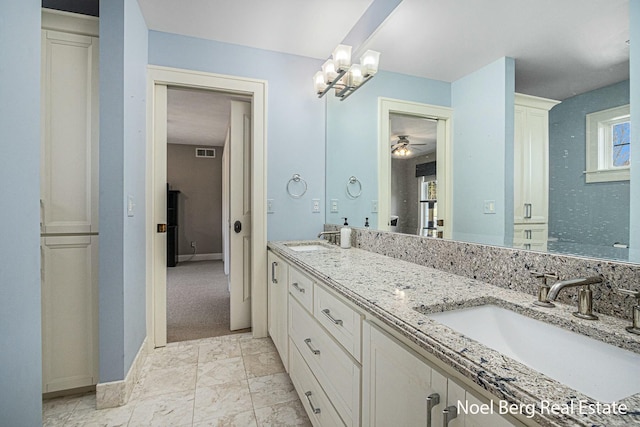 full bath with a sink, visible vents, and double vanity