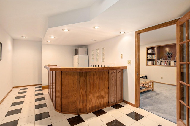 bar with recessed lighting, baseboards, a bar, and freestanding refrigerator