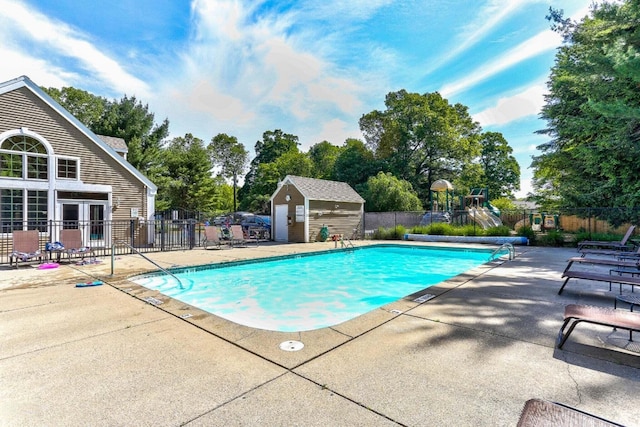 pool with a patio area and fence