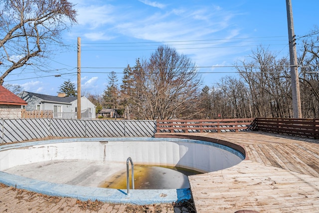 view of swimming pool with a deck and fence