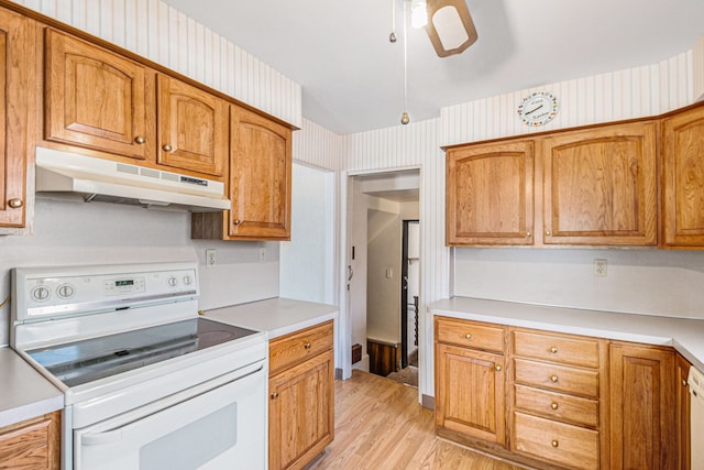 kitchen featuring under cabinet range hood, wallpapered walls, white appliances, light wood-style floors, and light countertops