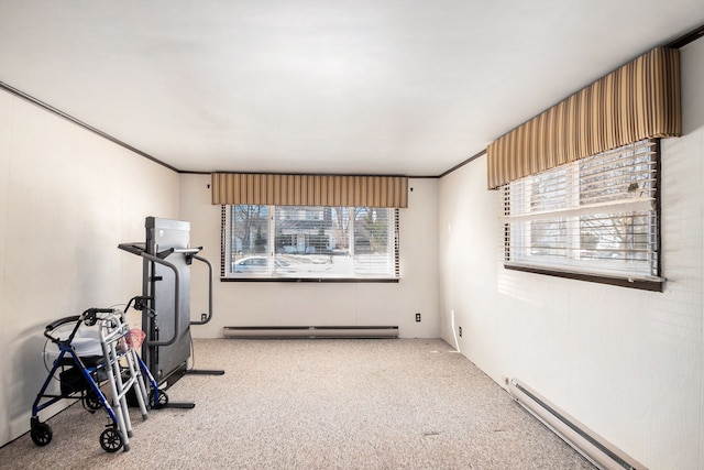 exercise room with ornamental molding, a baseboard heating unit, and carpet floors